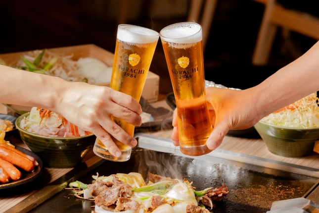 ビールグラスが乾杯している鉄板料理の風景