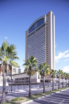 青空の下、近代的な高層ビルがそびえ立つ風景