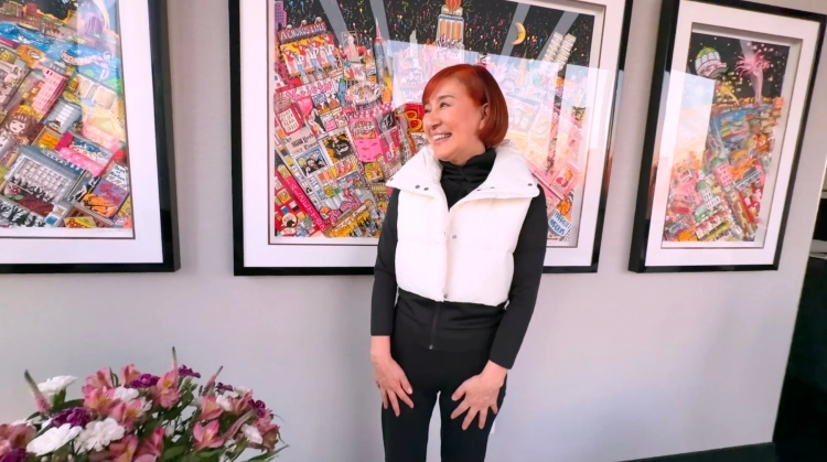 アートに囲まれた部屋に立つ松居さん