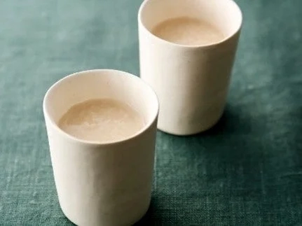 白い陶器のカップに入った淡い色の甘酒