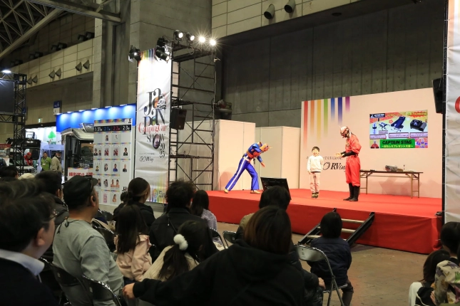 ジャパンキャンピングカーショーの会場でヒーローショーのようなステージイベント