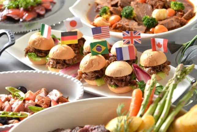 様々な国の国旗が飾られたミニバーガーが並ぶビュッフェ形式の食卓