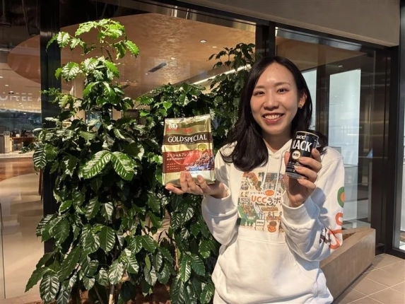 笑顔の女性がUCCのコーヒー商品を2つ紹介しています