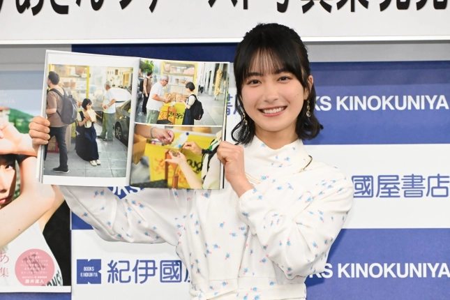 写真集を広げて見せる藤﨑ゆみあさん