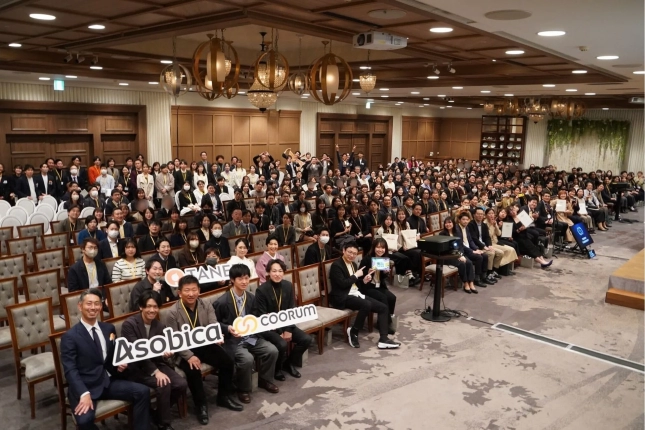 広々とした会場で、多数の参加者が着席している企業イベントの様子