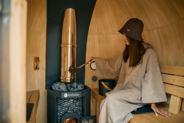 サウナでロウリュをする女性